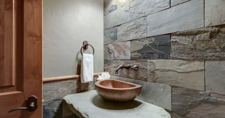 Une petite salle de bains avec un mur imitation pierre
