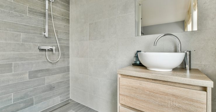 Une salle de bain ouverte avec un petit meuble lavabo en bois