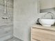 Une salle de bain ouverte avec un petit meuble lavabo en bois