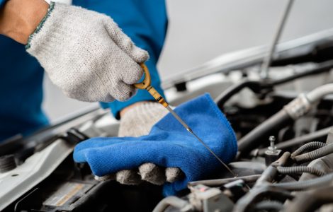 Un mécanicien en train de vérifier le niveau d’huile d’une voiture