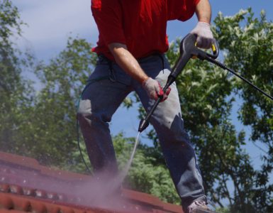 Un homme effectuant le lavage à haute pression d’une toiture en tuile