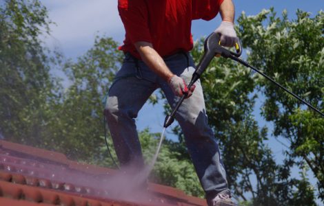 Un homme effectuant le lavage à haute pression d’une toiture en tuile