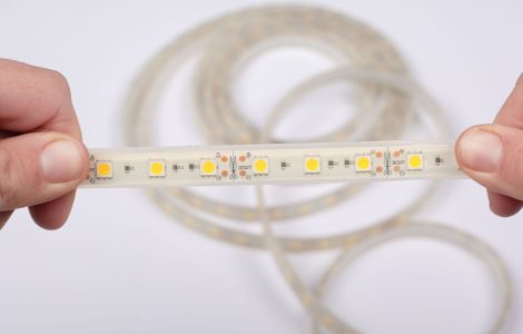 Zoom sur les mains d'une personne tenant un ruban à LED