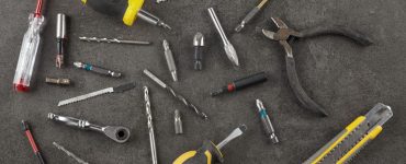 Différents outils posés sur une table : pince, tournevis, cutter...