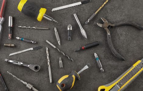 Différents outils posés sur une table : pince, tournevis, cutter...