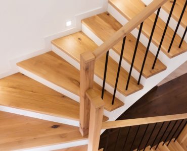 Un escalier en bois intérieur illuminé par des spots encastrés