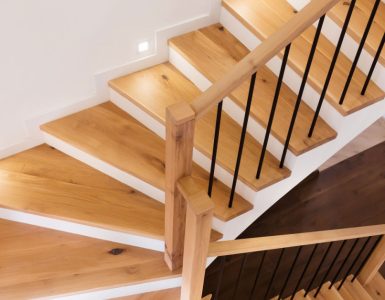 Un escalier en bois intérieur illuminé par des spots encastrés