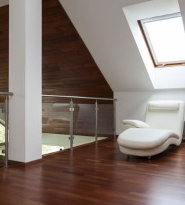 Un coin détente aménagé avec un fauteuil long sous une fenêtre de toit