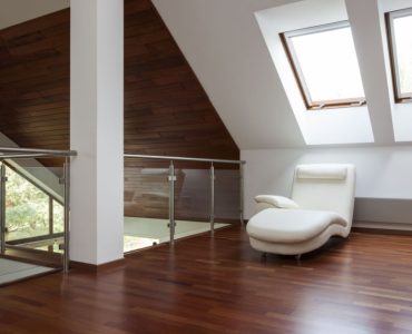 Un coin détente aménagé avec un fauteuil long sous une fenêtre de toit