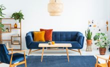 Canapé bleu marine en bois et coussins colorés dans un salon