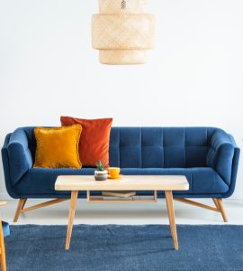 Canapé bleu marine en bois et coussins colorés dans un salon