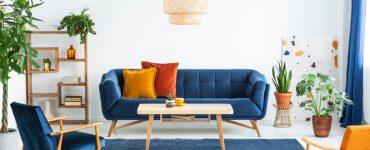 Canapé bleu marine en bois et coussins colorés dans un salon