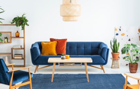 Canapé bleu marine en bois et coussins colorés dans un salon