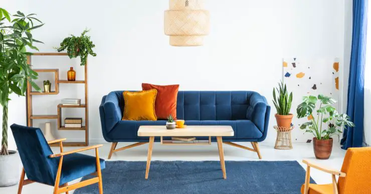 Canapé bleu marine en bois et coussins colorés dans un salon