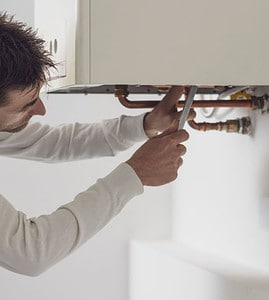Un plombier en train de contrôle la chaudière et les tuyaux