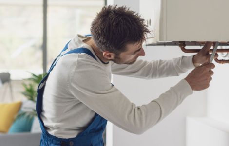 Un plombier en train de contrôle la chaudière et les tuyaux