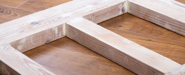 Une porte en bois récemment poncée, posée sur le parquet