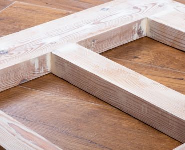 Une porte en bois récemment poncée, posée sur le parquet