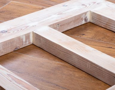 Une porte en bois récemment poncée, posée sur le parquet