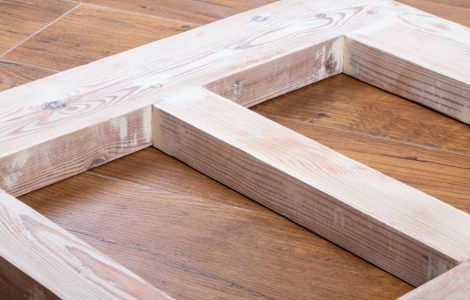 Une porte en bois récemment poncée, posée sur le parquet