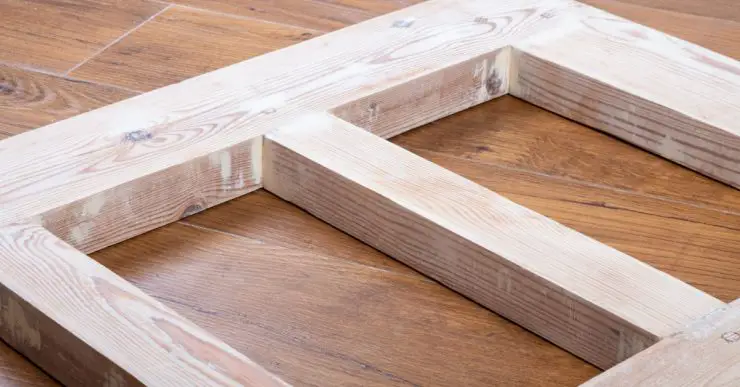 Une porte en bois récemment poncée, posée sur le parquet