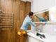 Un homme installant un miroir sur le mur d'une salle de bains