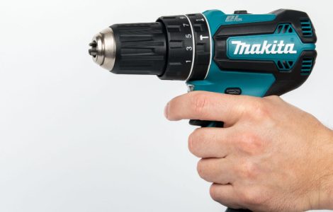 Zoom sur la main d’un homme tenant une perceuse électrique