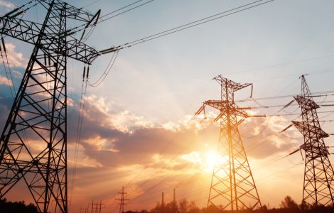 Des lignes électriques à haute tension avec le soleil couchant en fond