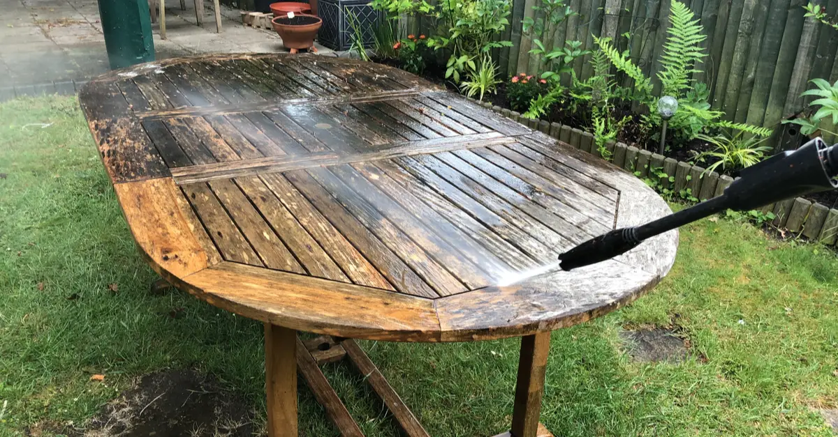 Nettoyage d'une table en bois par jet d'eau