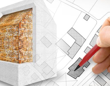 Zoom sur la main d'un homme tenant un crayon et dessinant le plan d'isolation thermique d'une maison