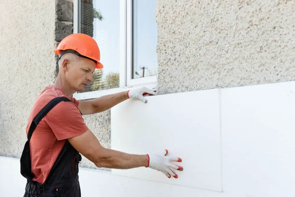 La maison est enveloppée en tout ou en partie de plaques isolantes qui seront par la suite enduites ou recouvertes d'un bardage esthétique