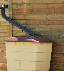 Zoom sur une cuve de récupération d'eau de pluie d'une maison en bois