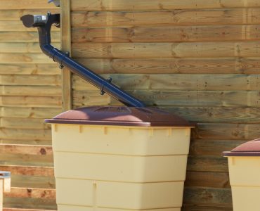 Zoom sur une cuve de récupération d'eau de pluie d'une maison en bois