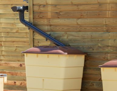 Zoom sur une cuve de récupération d'eau de pluie d'une maison en bois