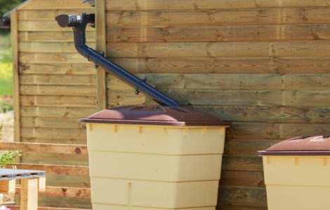 Zoom sur une cuve de récupération d'eau de pluie d'une maison en bois