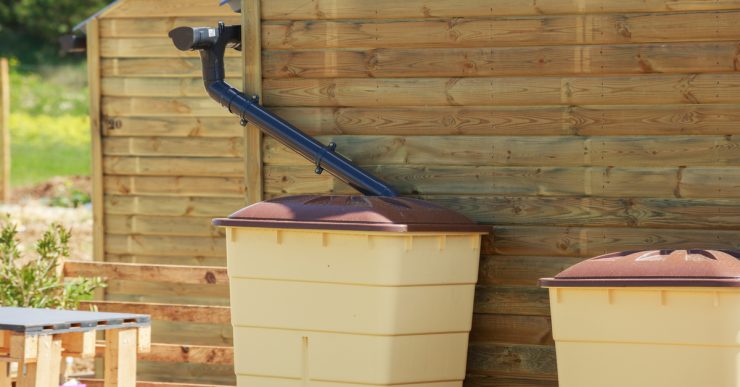 Zoom sur une cuve de récupération d'eau de pluie d'une maison en bois