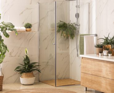 Salle de bains moderne avec douche vitrée, meuble en bois et plantes intérieures