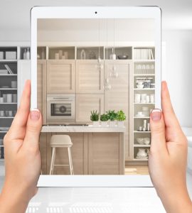 Mains tenant une tablette montrant une cuisine moderne blanche et en bois