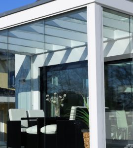 Des chaises noires et blanches dans une véranda blanche