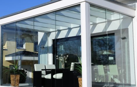 Des chaises noires et blanches dans une véranda blanche