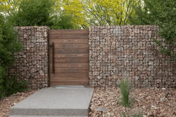 Une clôture en pierre grillagée qui s'harmonise parfaitement à un portillon en bois