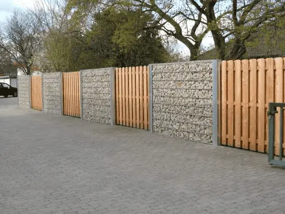 Une clôture qui mélange mur en gabion et panneau en bois occultant  