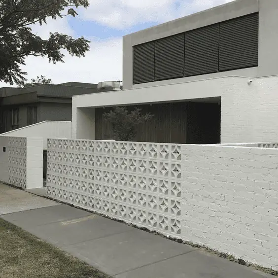 Un haut muret en breeze block devant une maison