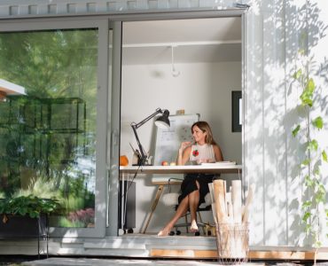 Vue sur une femme assise dans une petite maison en container