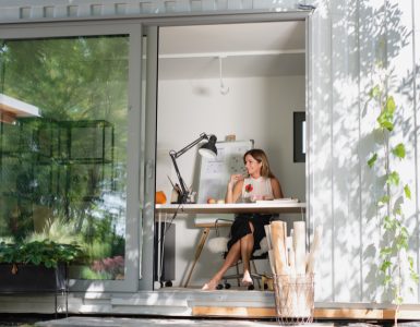 Vue sur une femme assise dans une petite maison en container