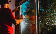 Un homme vérifie l'isolation d'une fenêtre vitrée