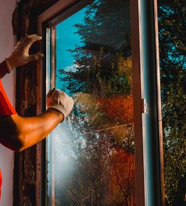 Un homme vérifie l'isolation d'une fenêtre vitrée