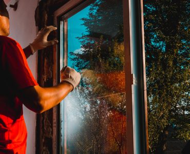 Un homme vérifie l'isolation d'une fenêtre vitrée