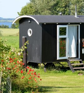 Un mobile home noir et blanc placé dans le jardin