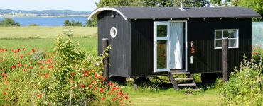 Un mobile home noir et blanc placé dans le jardin